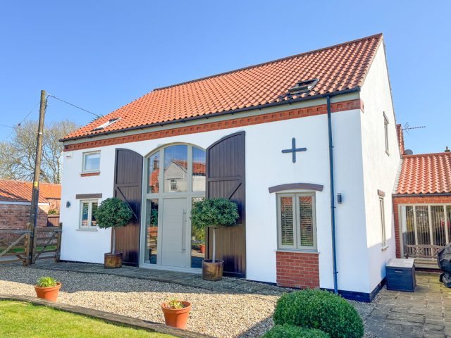 Mediterranean style white render and terracotta-colored roof tiled Lincolnshire barn conversion